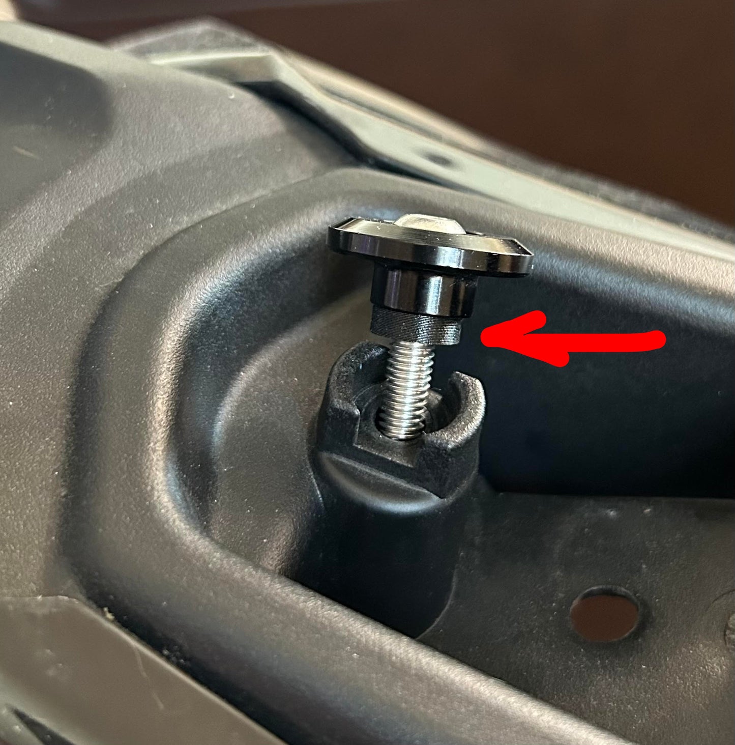 red arrow pointing at installed thick, washer shaped seat spacer.